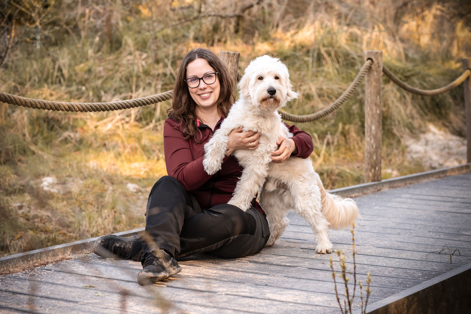 Fotografin Mandy Hoffmann sitzt mit Hund auf einem Steg