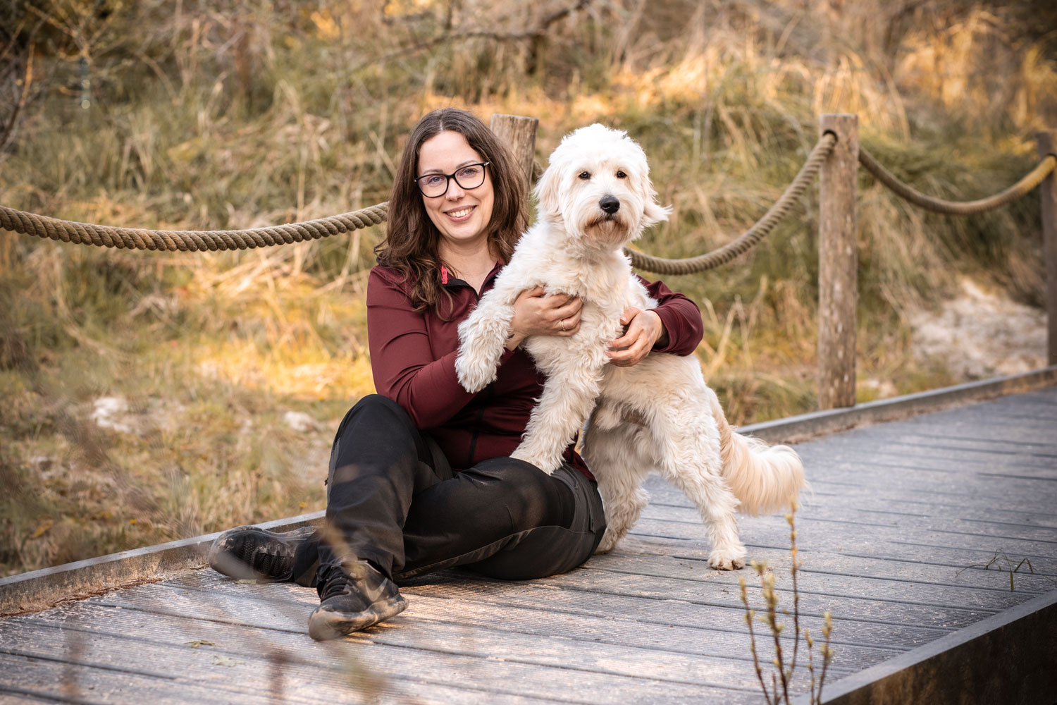 Fotografin Mandy Hoffmann sitzt mit Hund auf einem Steg