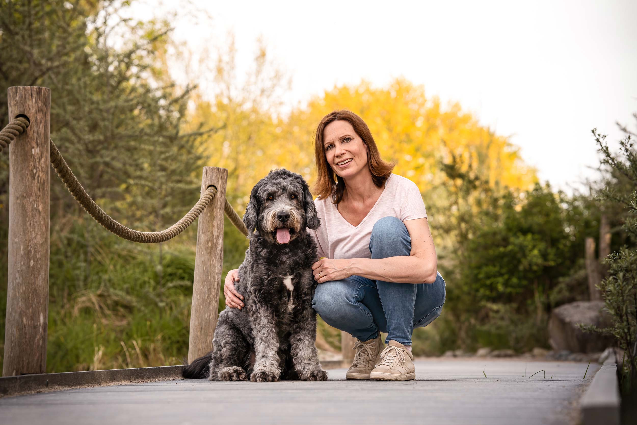 Frau hockt neben Hund