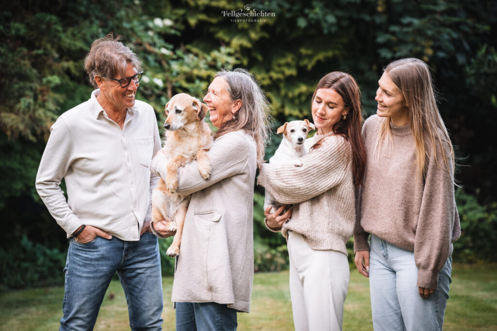 Eine Familie mit zwei Hunden auf dem Arm